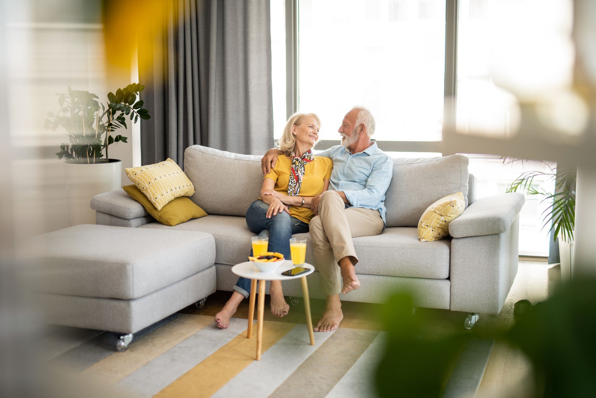 An elderly couple is sitting on a couch in a living room - Worcester, MA - Larson's Home Improvement