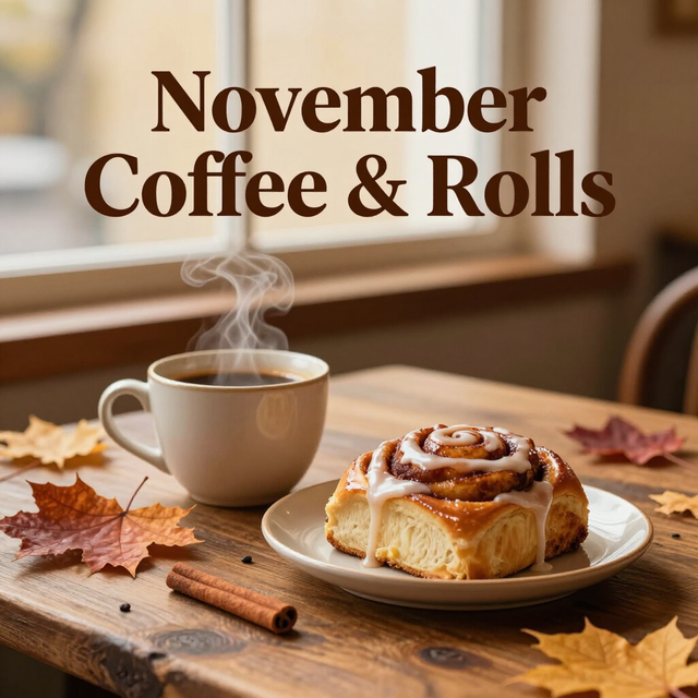 Coffee mug and a cinnamon roll on a table with autumn leaves; text reads “November Coffee and Rolls”
