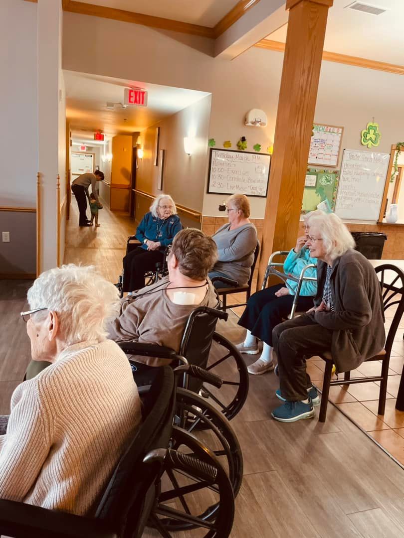 A group of elderly people in wheelchairs are sitting in a room.