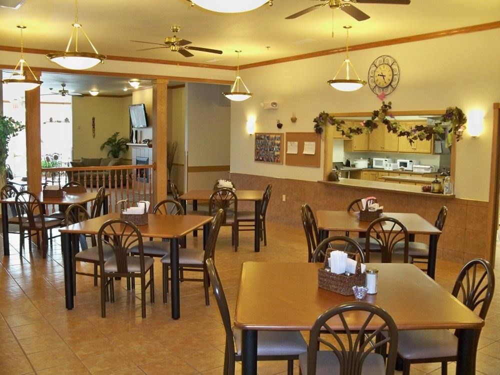 A dining room with tables and chairs and a clock on the wall