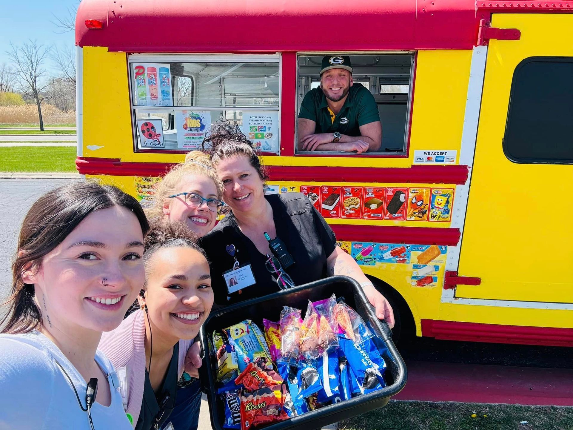A group of people are posing for a picture in front of an ice cream truck.