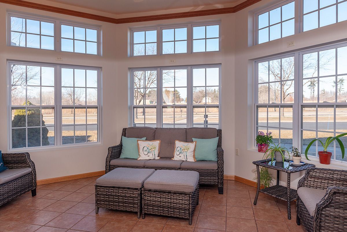 A living room filled with furniture and lots of windows.