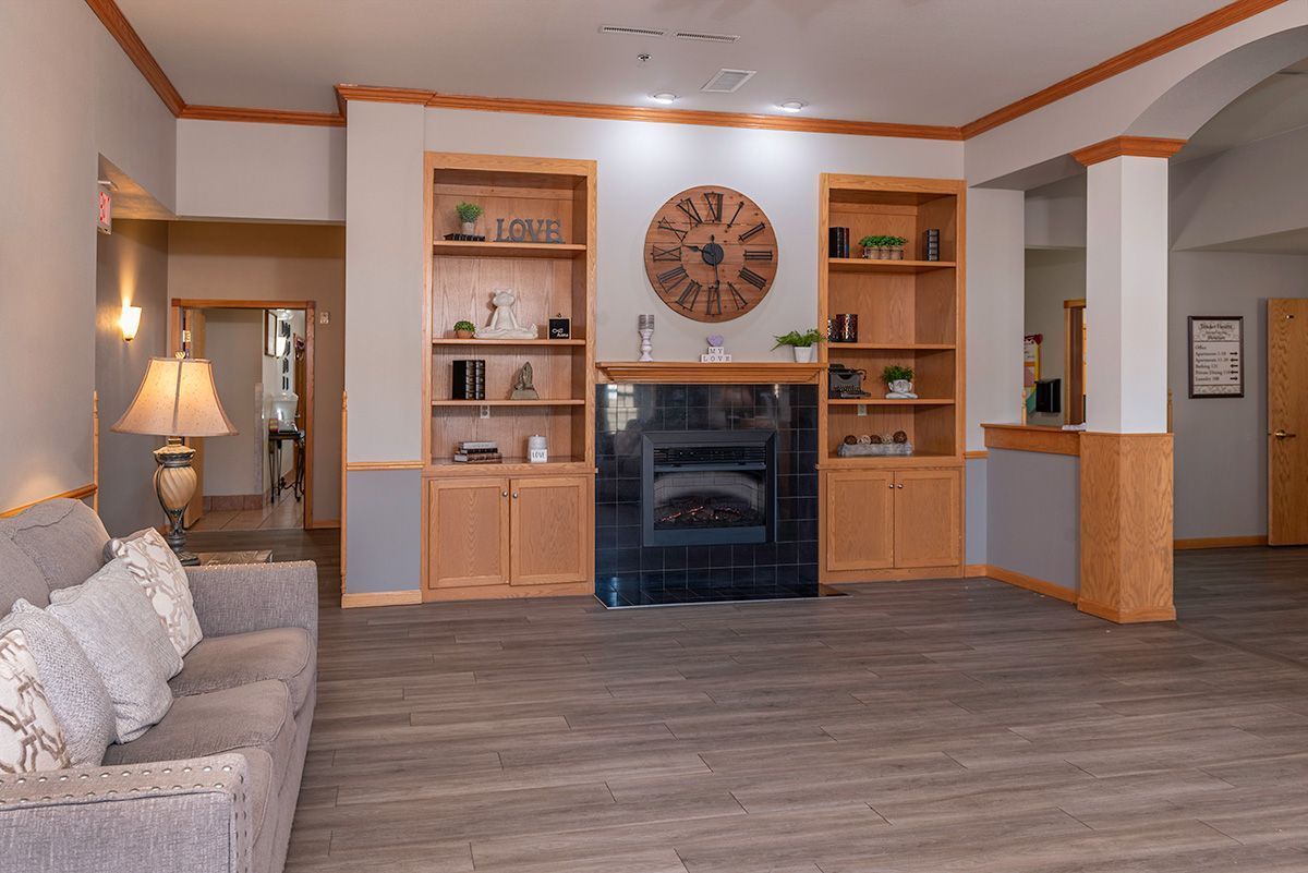 A living room with a fireplace and a clock on the wall.