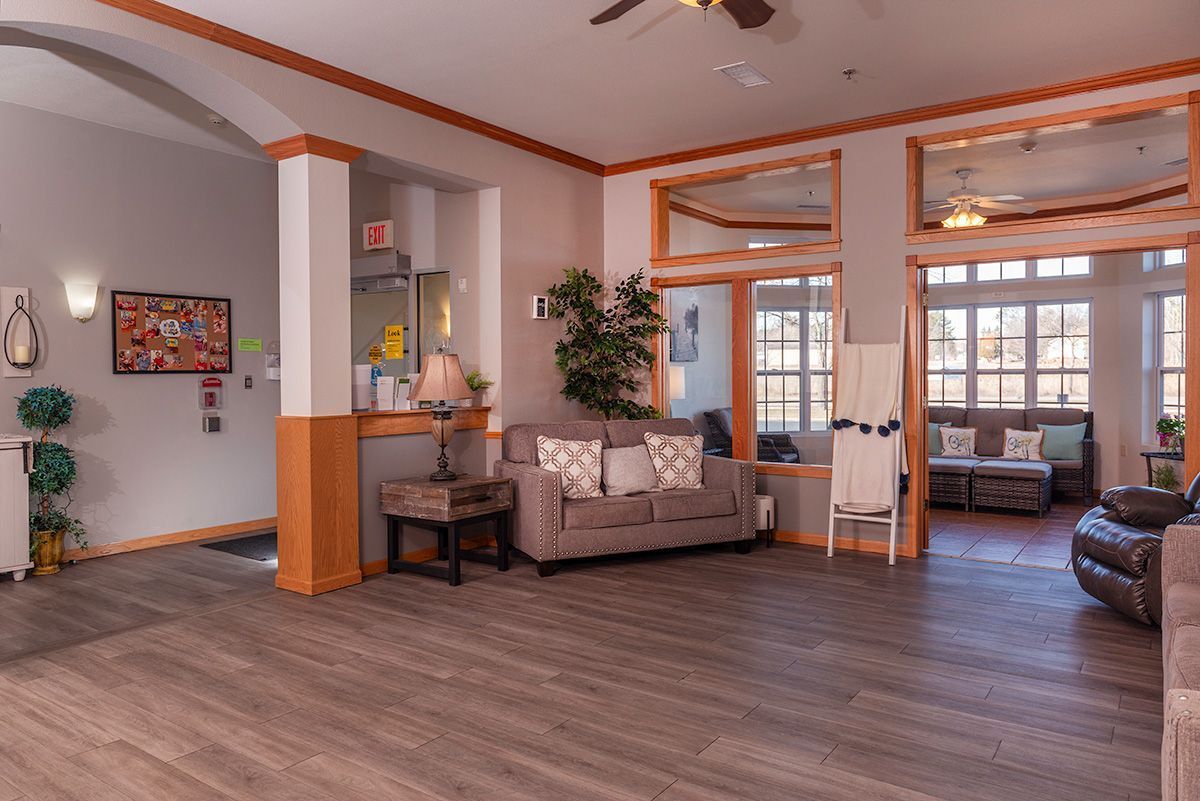 A living room with a couch , chairs , and a ceiling fan.