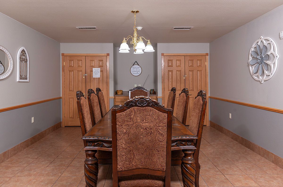 A dining room with a long table and chairs
