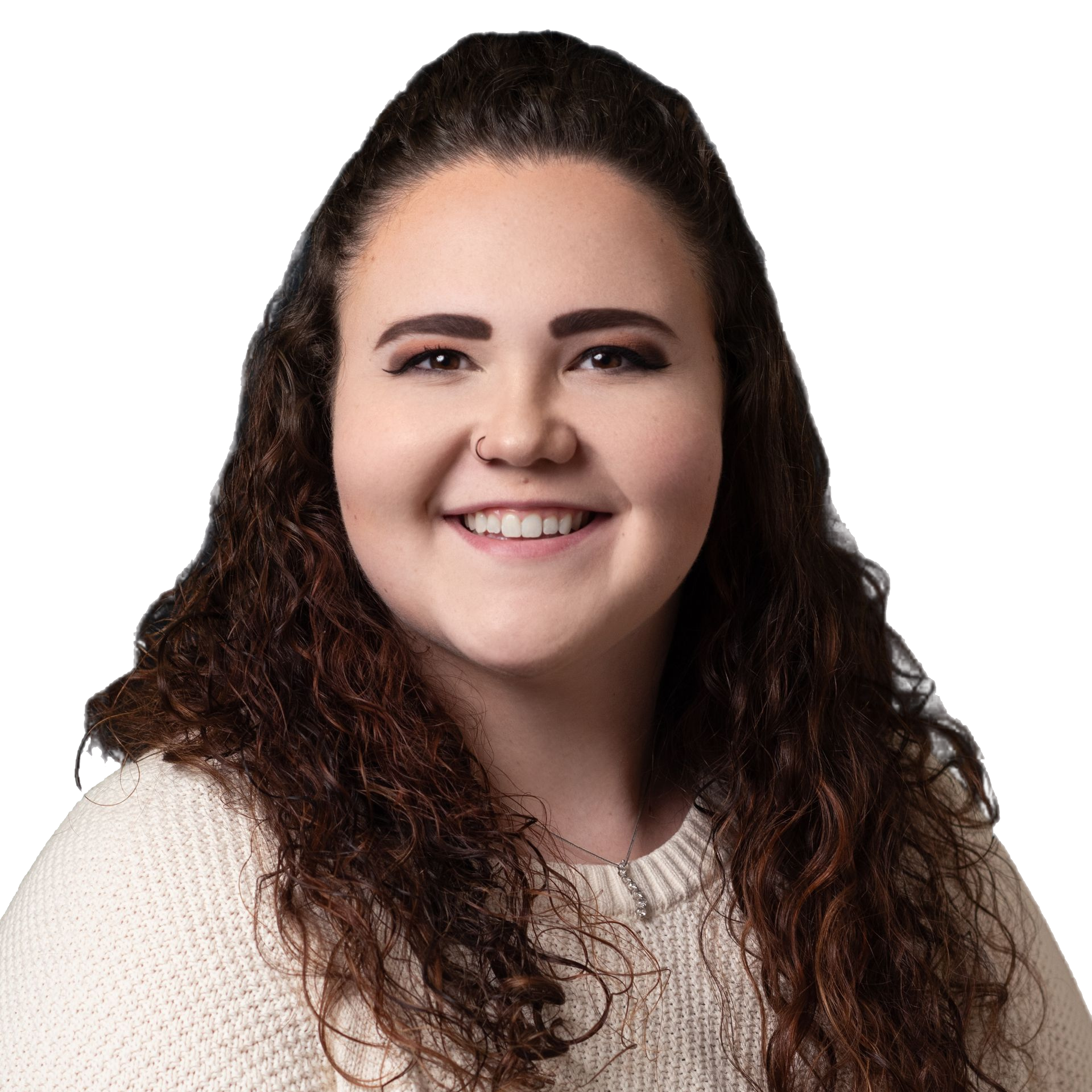 Woman with curly brown hair smiling, wearing a cream sweater. Nose ring.