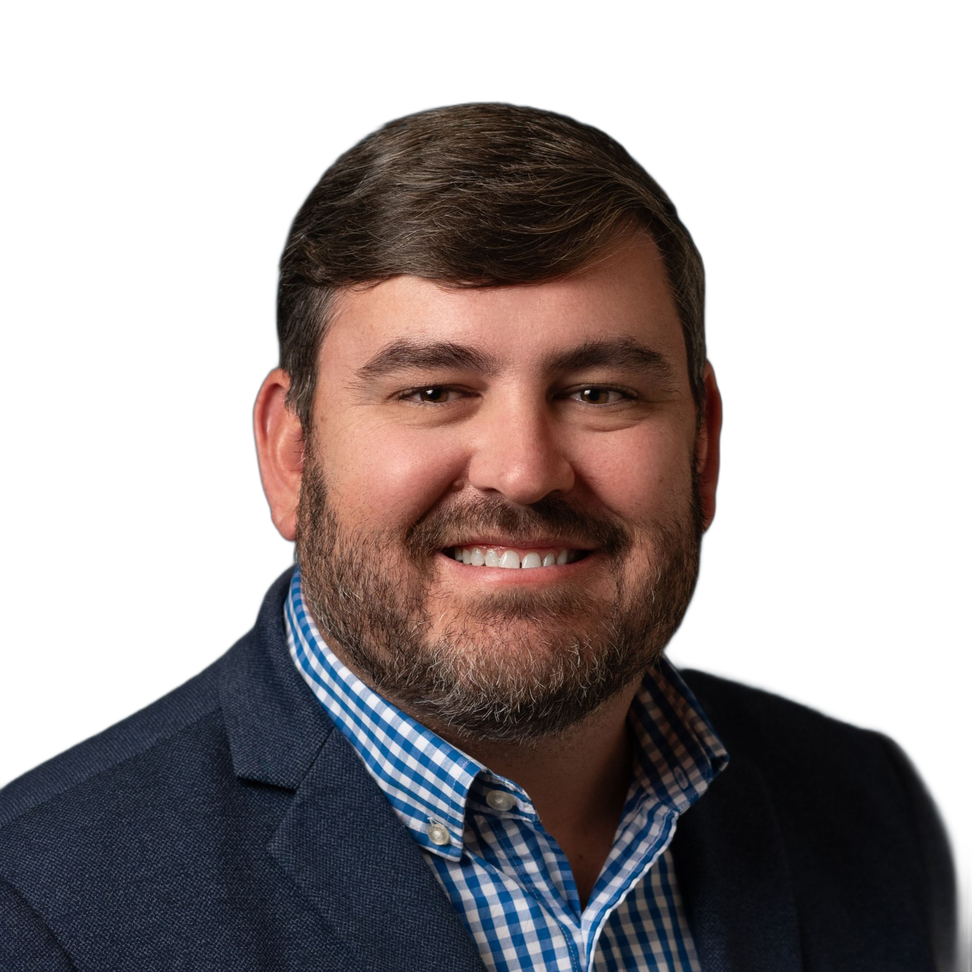 Man with beard smiles, wearing a blue blazer over a checkered shirt.