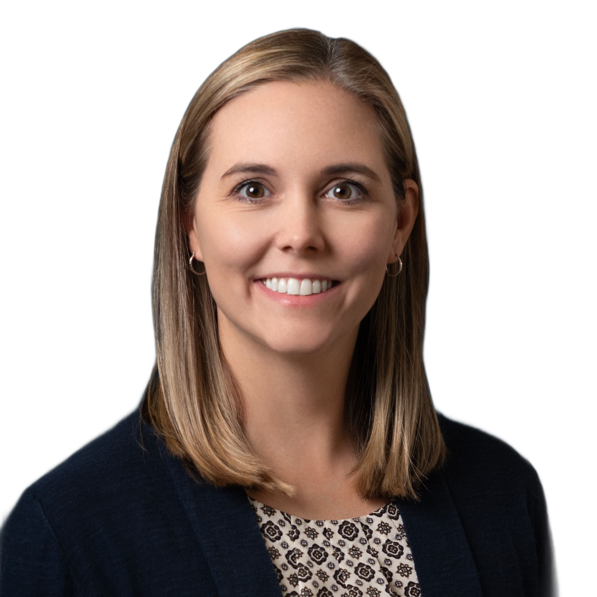 Woman with shoulder-length blonde hair, wearing a navy blazer and patterned blouse, smiling.
