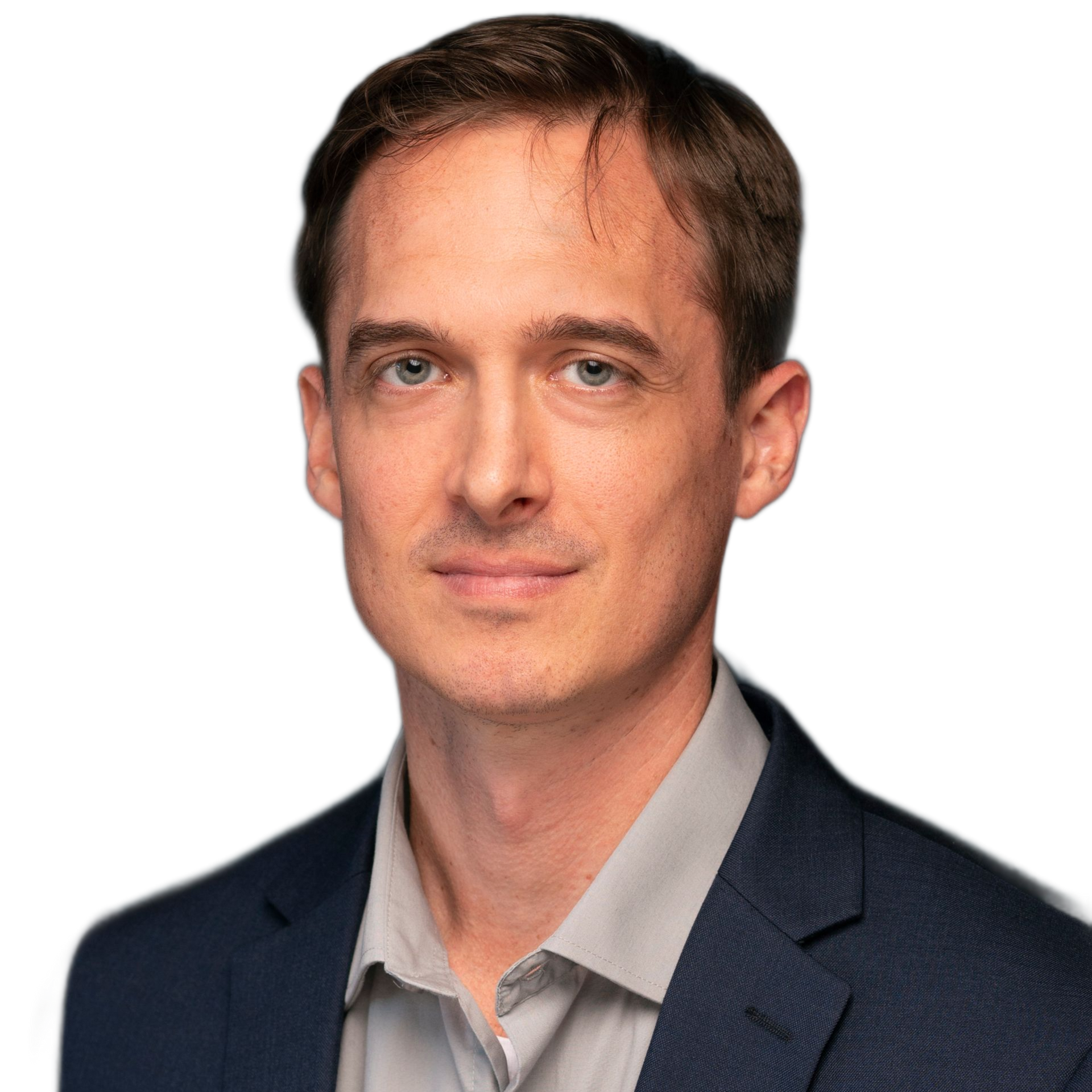 Man in navy blazer and grey shirt, looking at the camera.