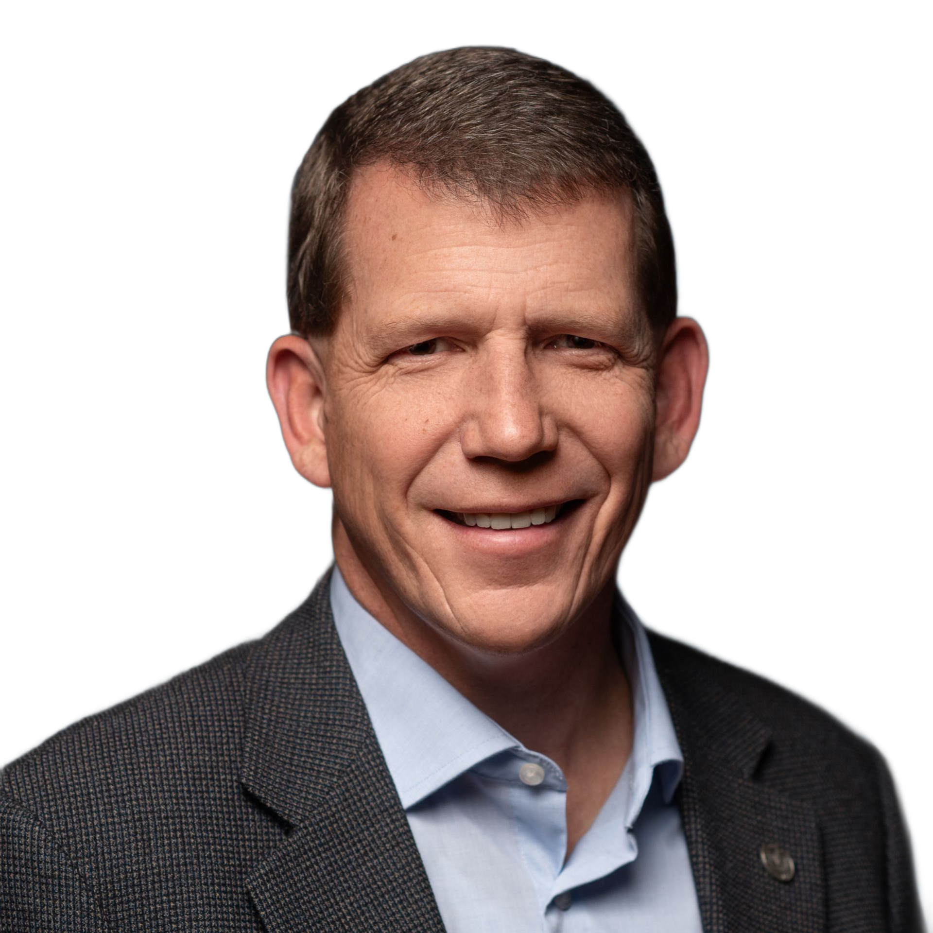 Man in a blue shirt and grey blazer smiling at the camera.