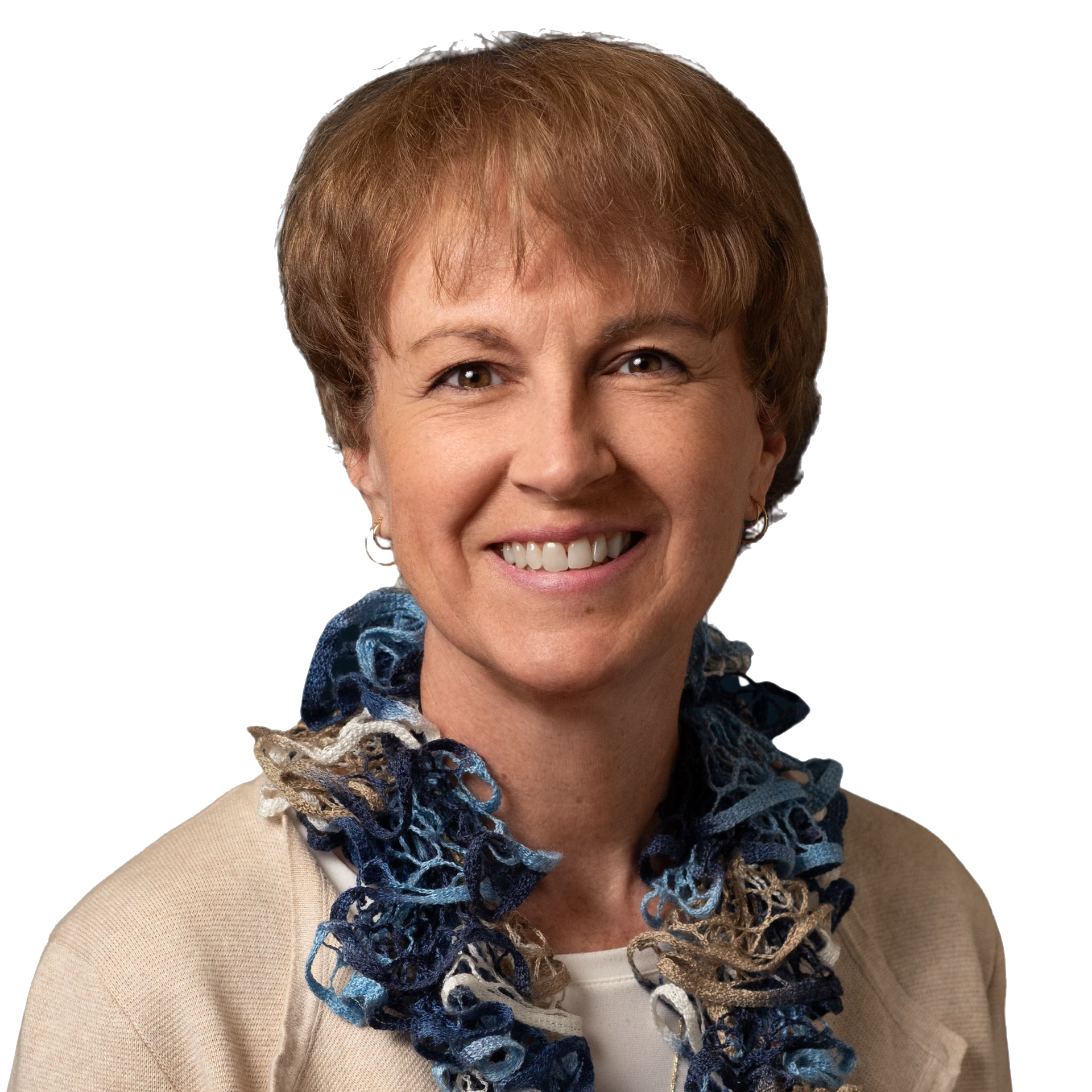 Woman smiling, wearing a cream sweater and a blue and brown scarf.
