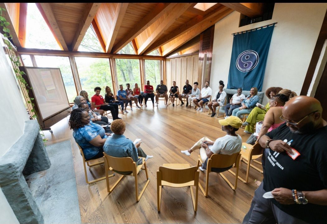 A group of people are sitting in a circle in a room