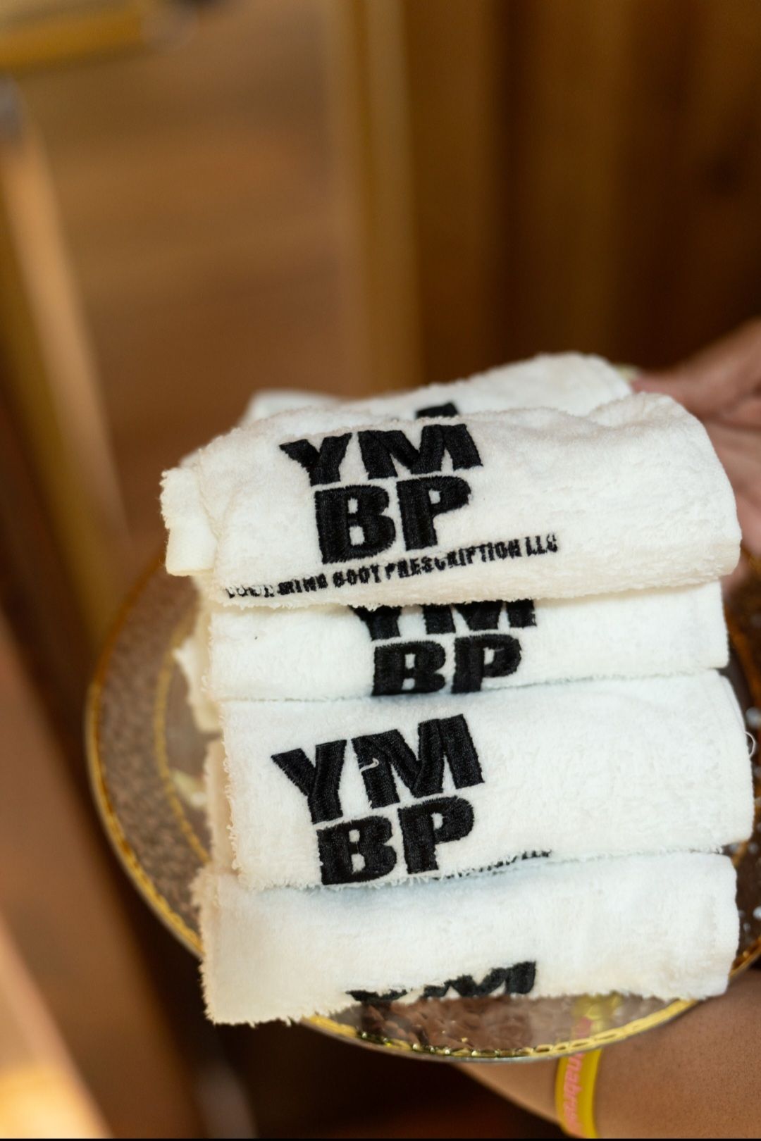 A person is holding a stack of ym bp towels