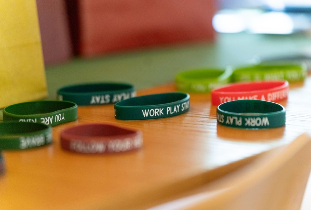 A bunch of bracelets on a table with one that says work play stay