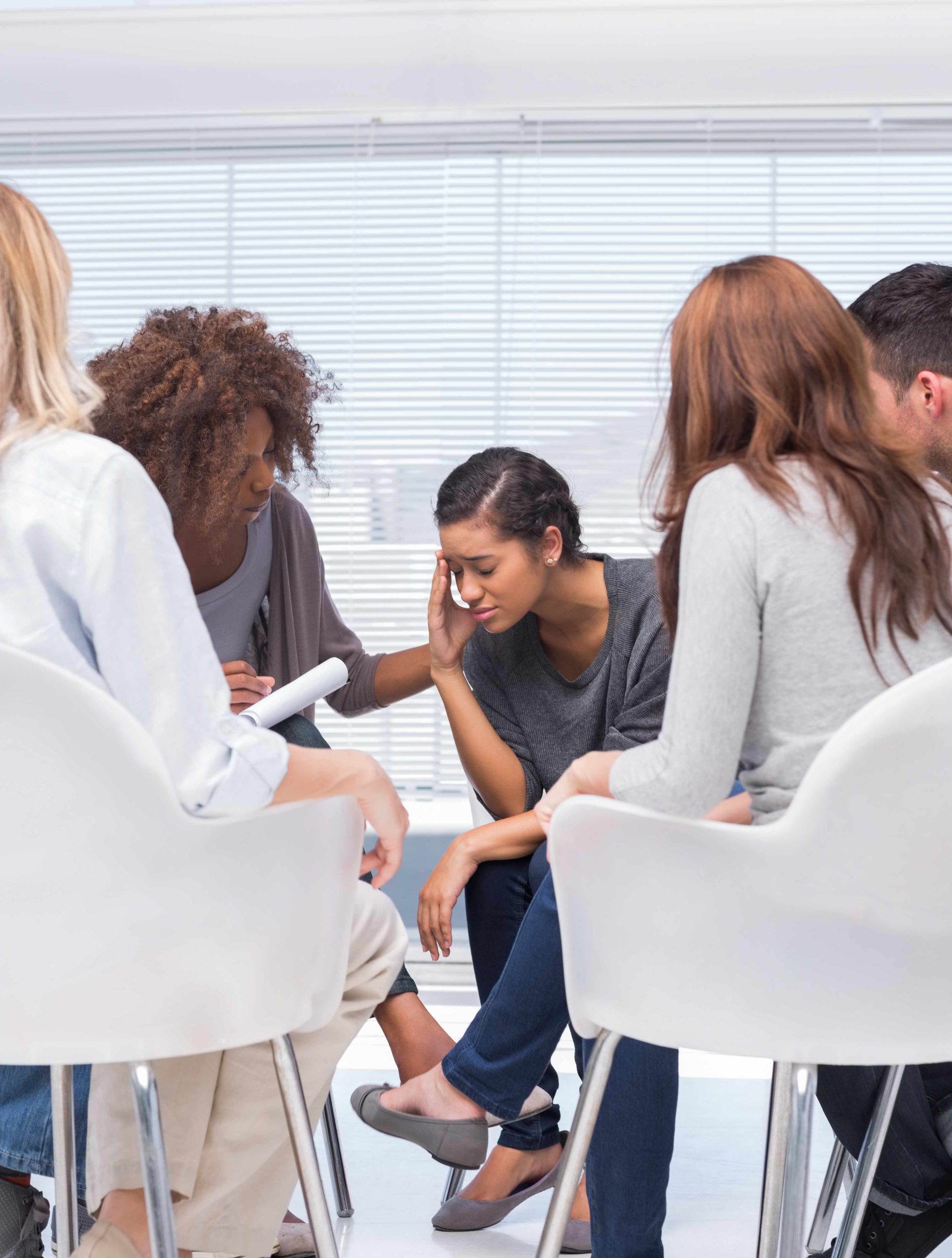 a group of people are sitting in a circle talking to each other