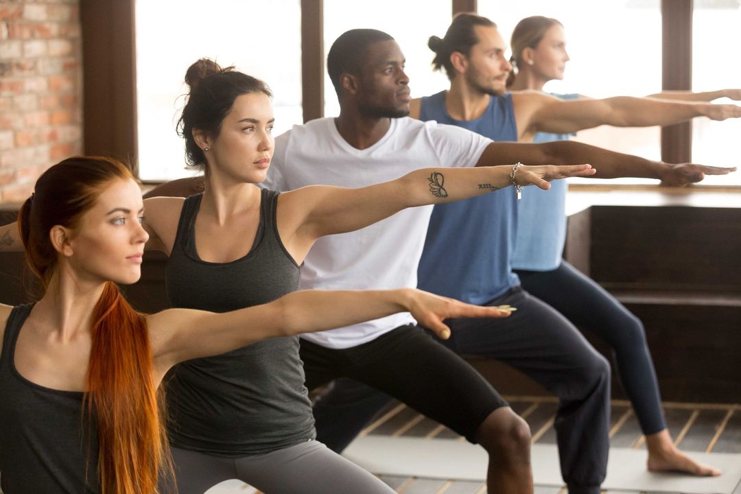 a group of people are doing yoga together in a gym
