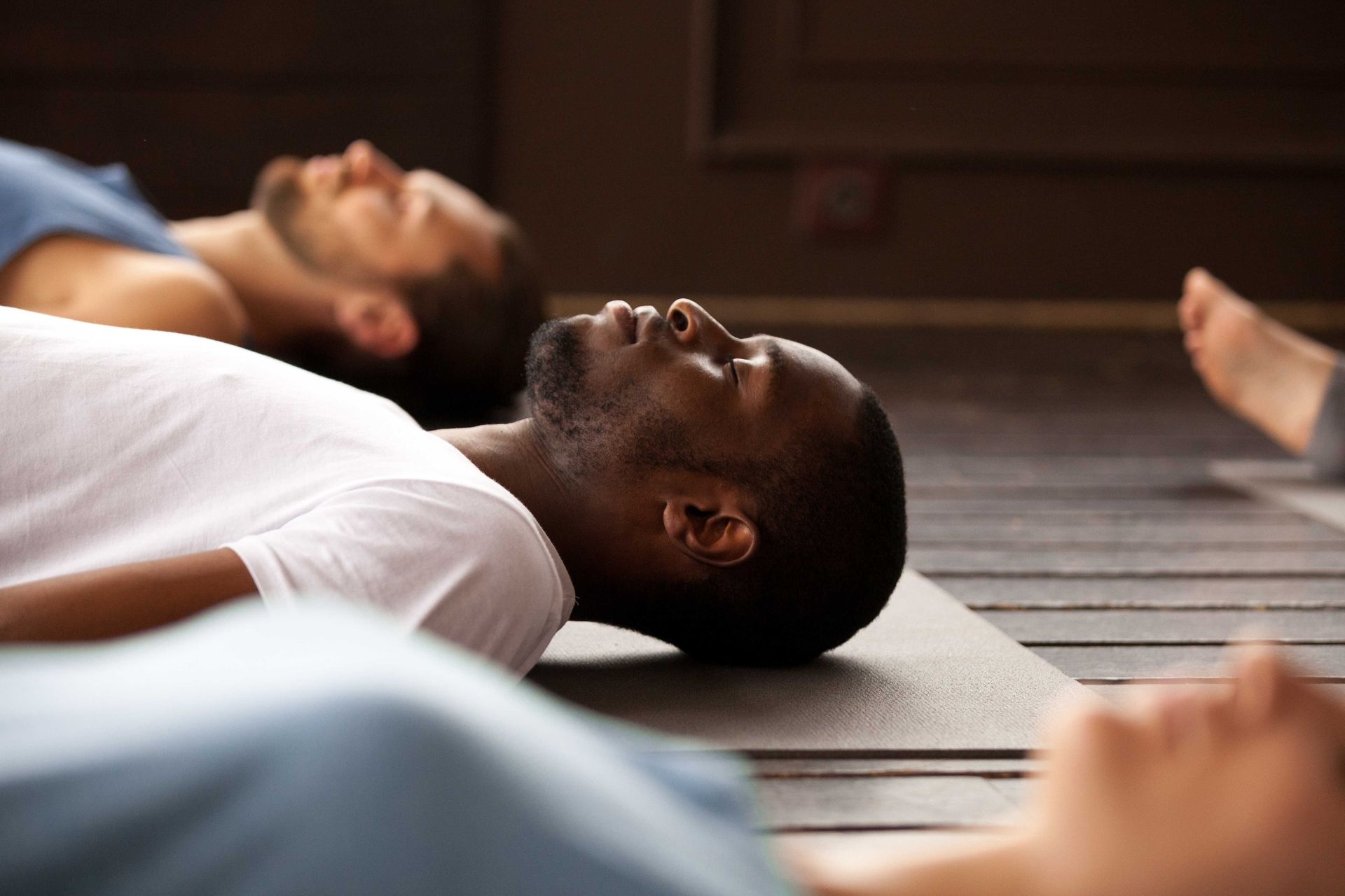 a man is laying on a yoga mat on the floor