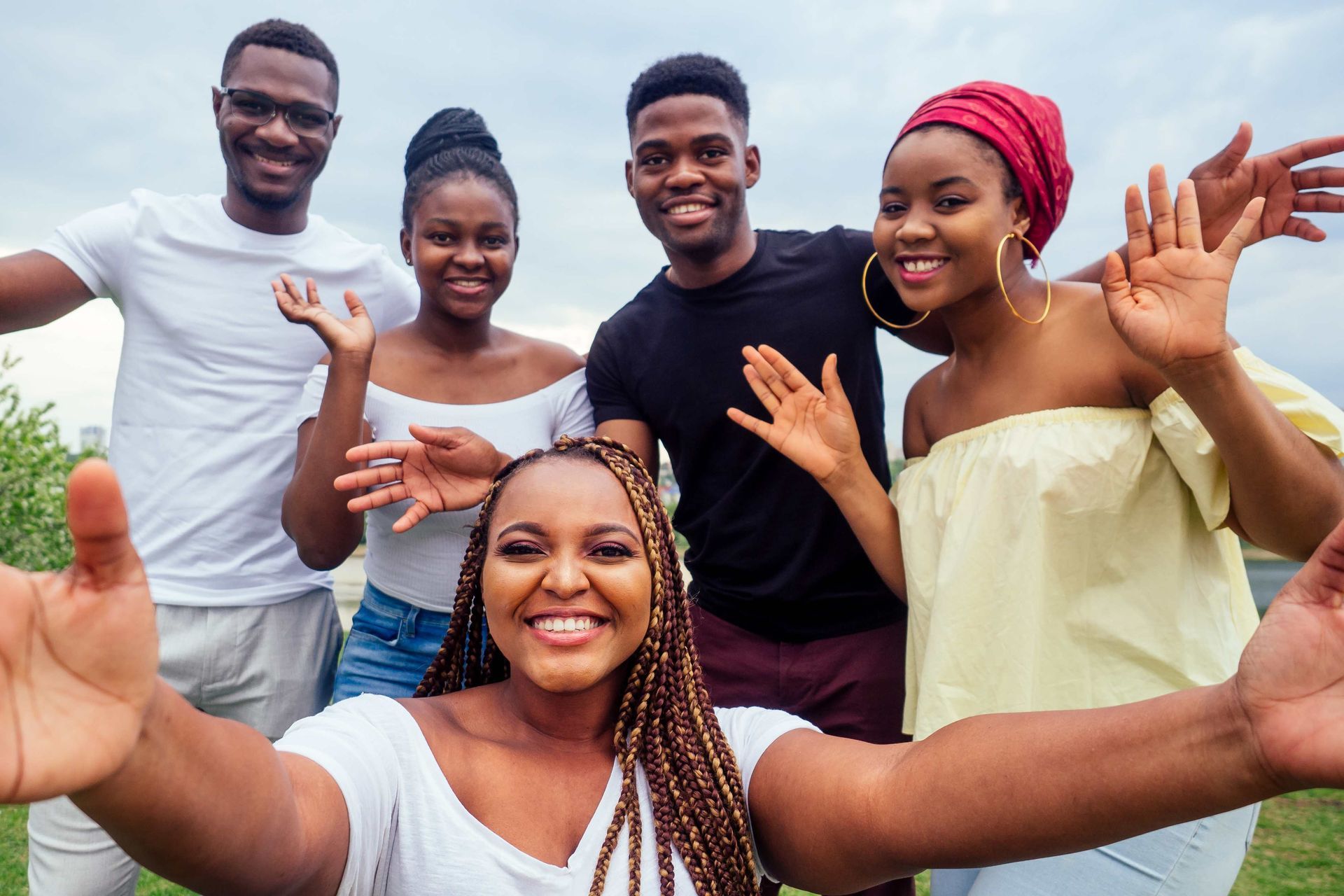 a group of young people are taking a selfie in a park