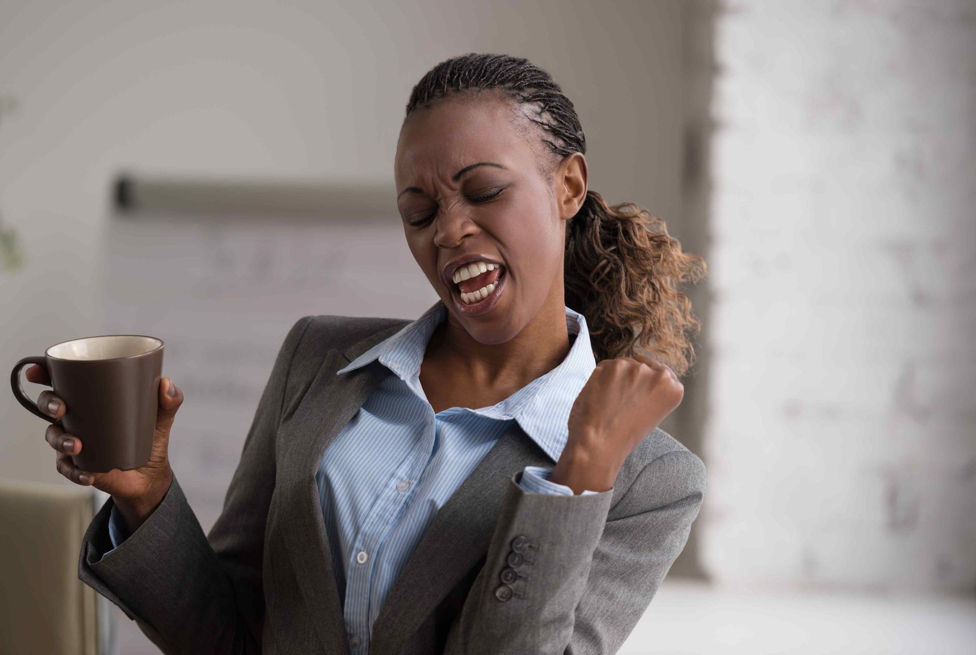 a woman in a suit is holding a cup of coffee
