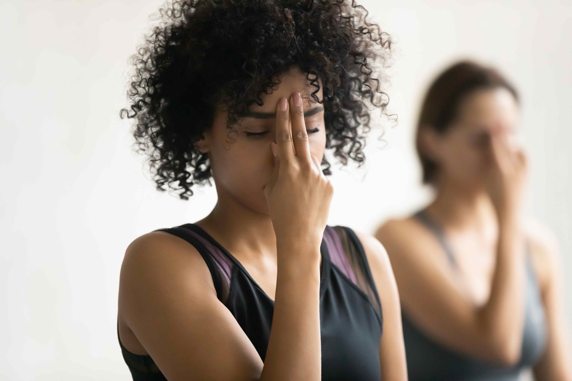 a woman is covering her nose with her hand while another woman looks on