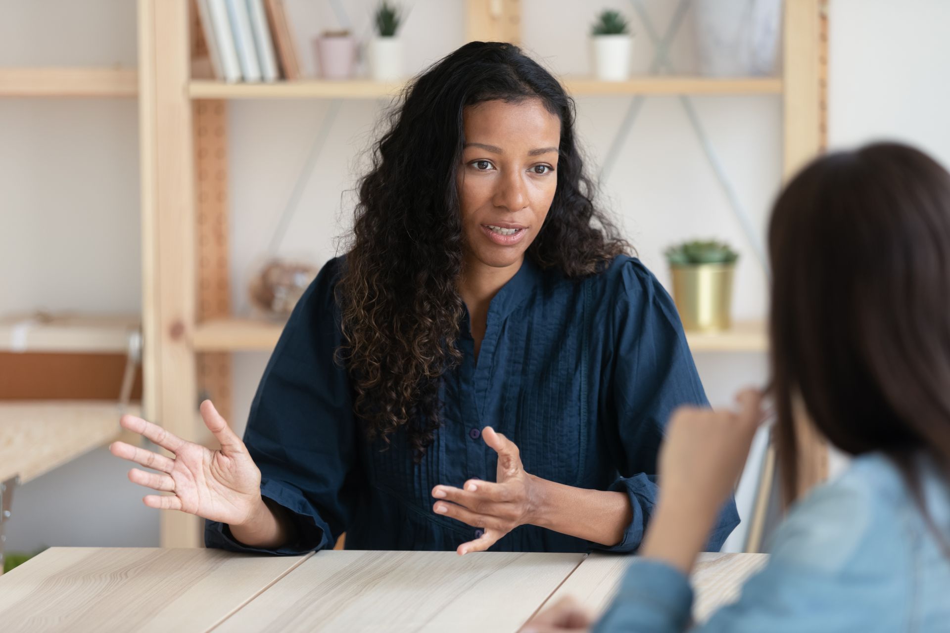 a woman is sitting on a couch talking to a man and woman
