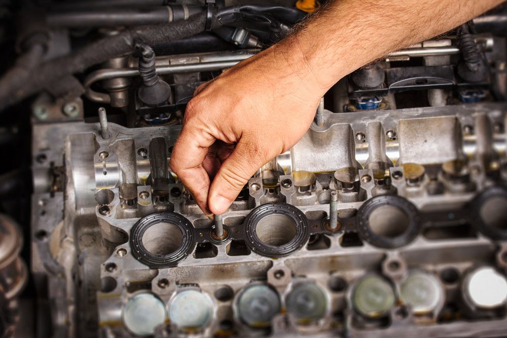 A Man Is Working on A Car Engine with A Wrench — A & K Auto Electrical & Air Conditioning in Gunnedah, NSW