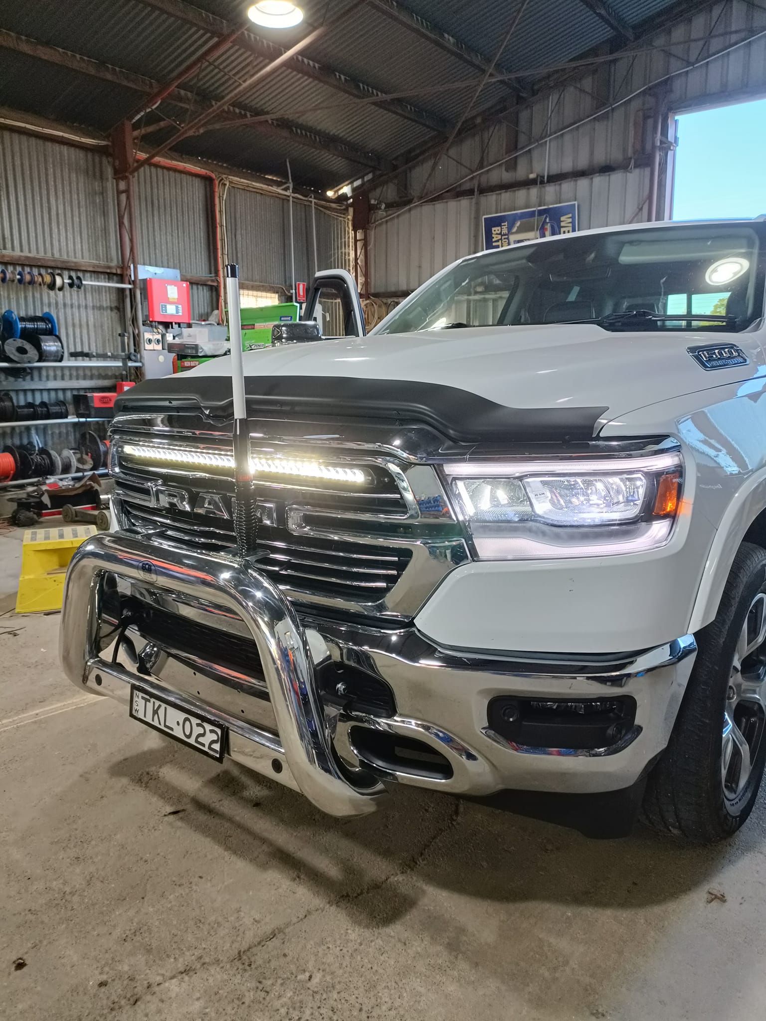 Vehicle headlights on in workshop during inspection by auto electrician checking lighting system