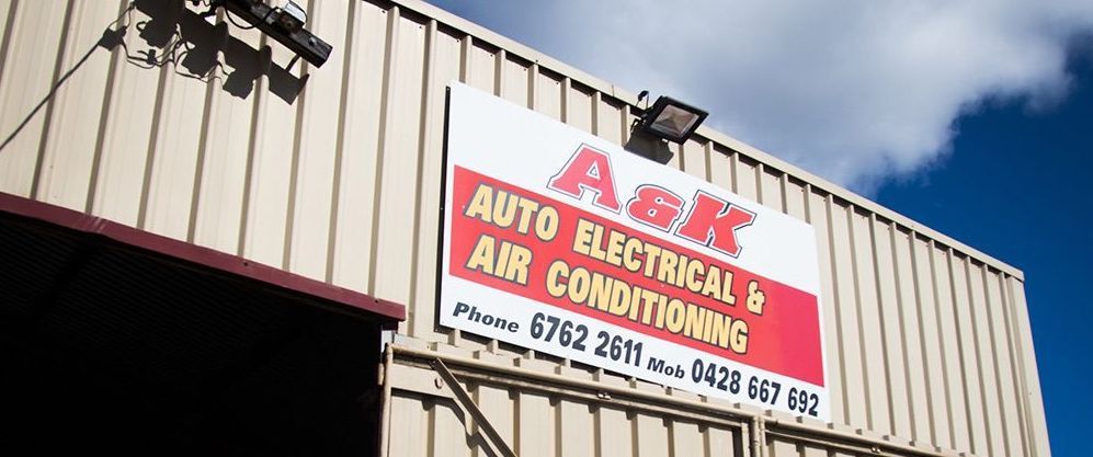Auto electrician holding a red clipboard while smiling — Auto Electrical & Air Conditioning in Tamworth, NSW