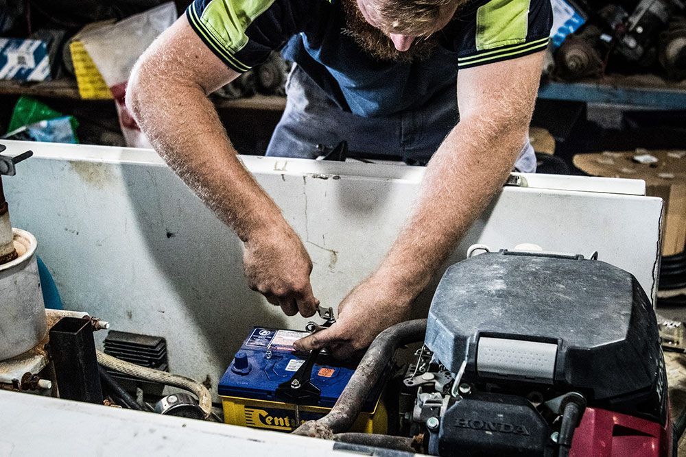 Technician using jumper leads to jump-start a car battery — Auto Electrical & Air Conditioning in Tamworth, NSW