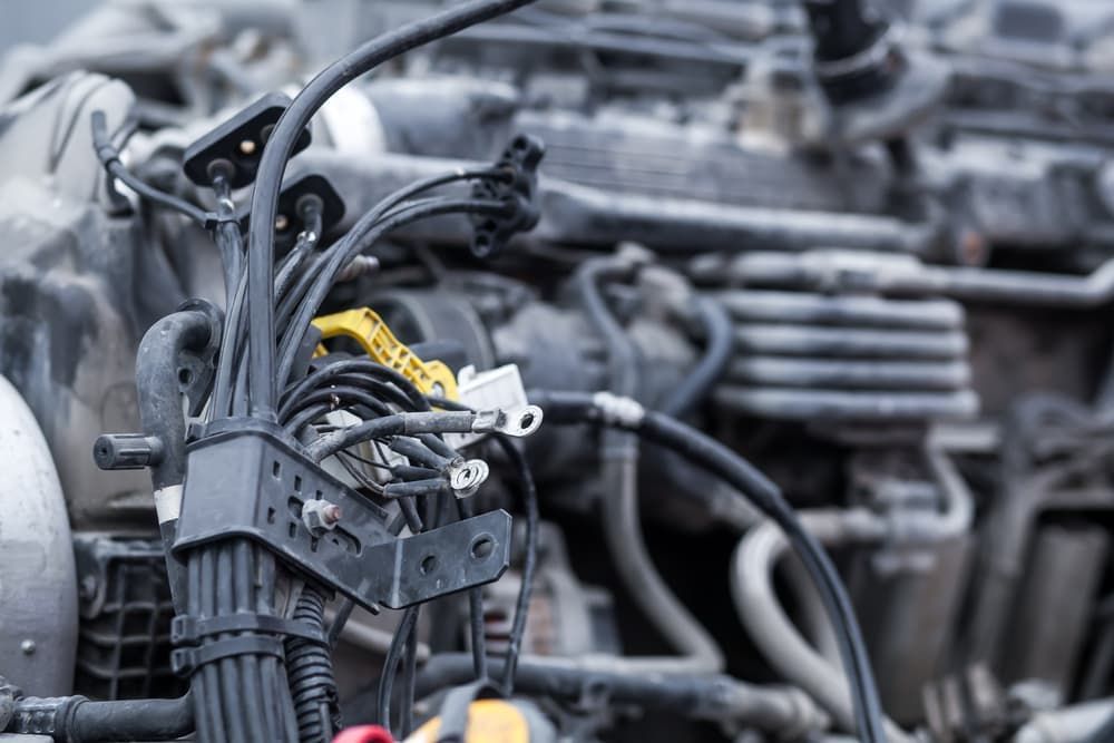 A Man Is Charging A Car Battery With A Charger — Auto Electrical & Air Conditioning in Armidale, NSW