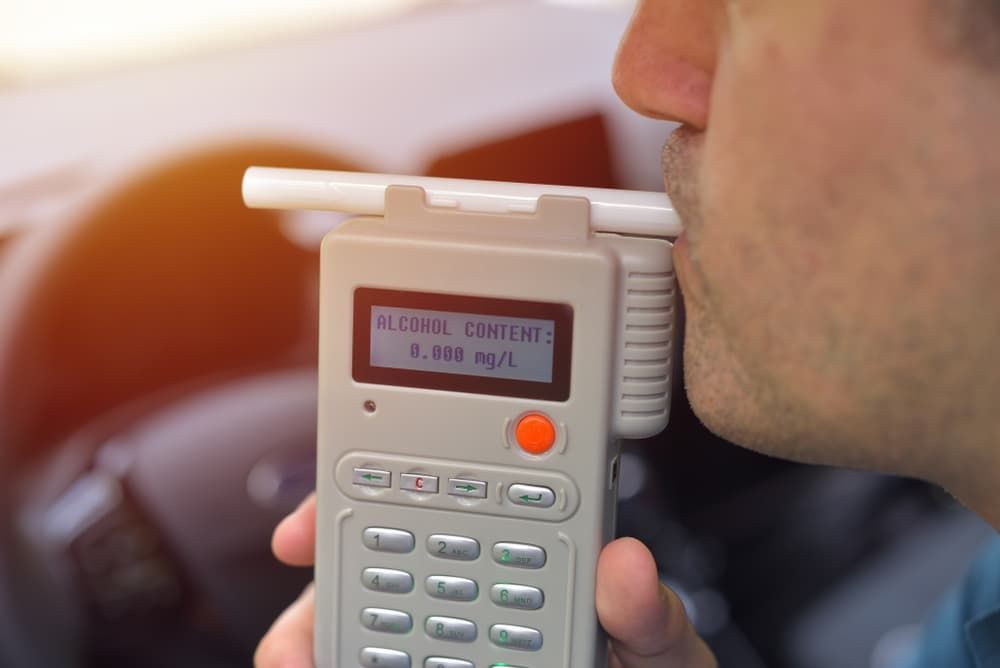 Man taking an alcohol breath test in his car — Auto Electrical & Air Conditioning in Tamworth, NSW