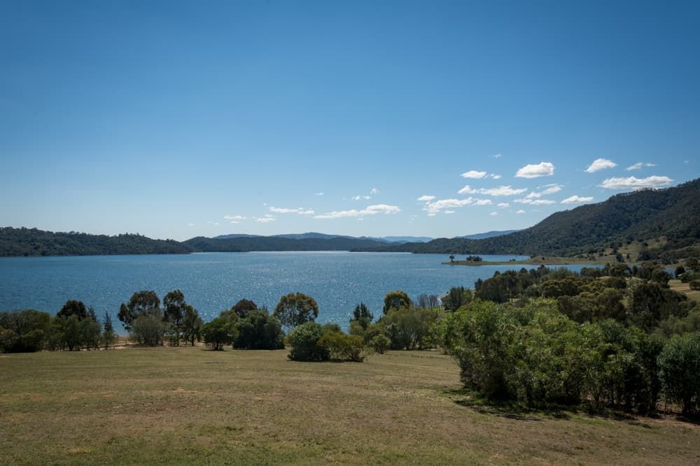 A Large Body Of Water Surrounded By Trees And Grass On A Sunny Day — Auto Electrical & Air Conditioning in Scone, NSW