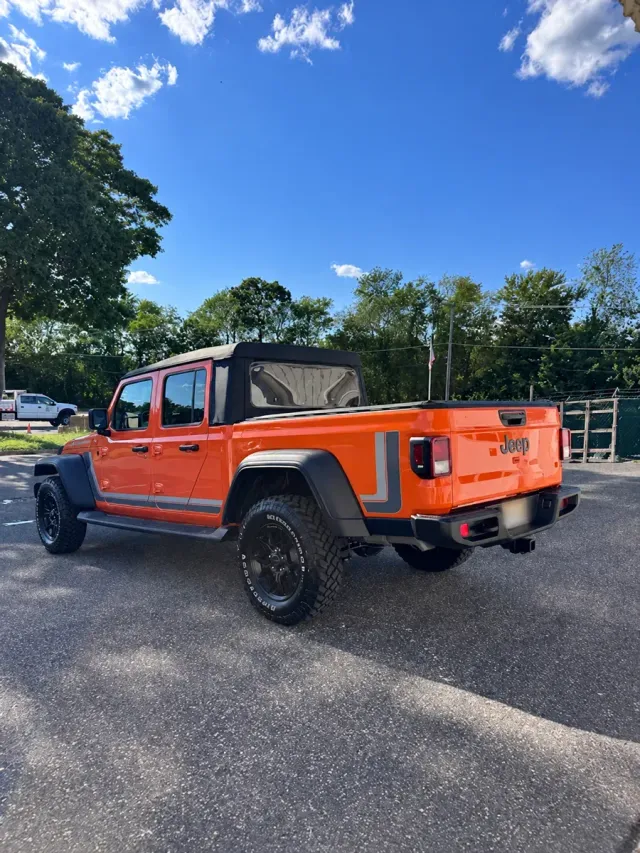 Orange Jeep Gladiator after rear-end collision repairs at Auto Craftman and Collision