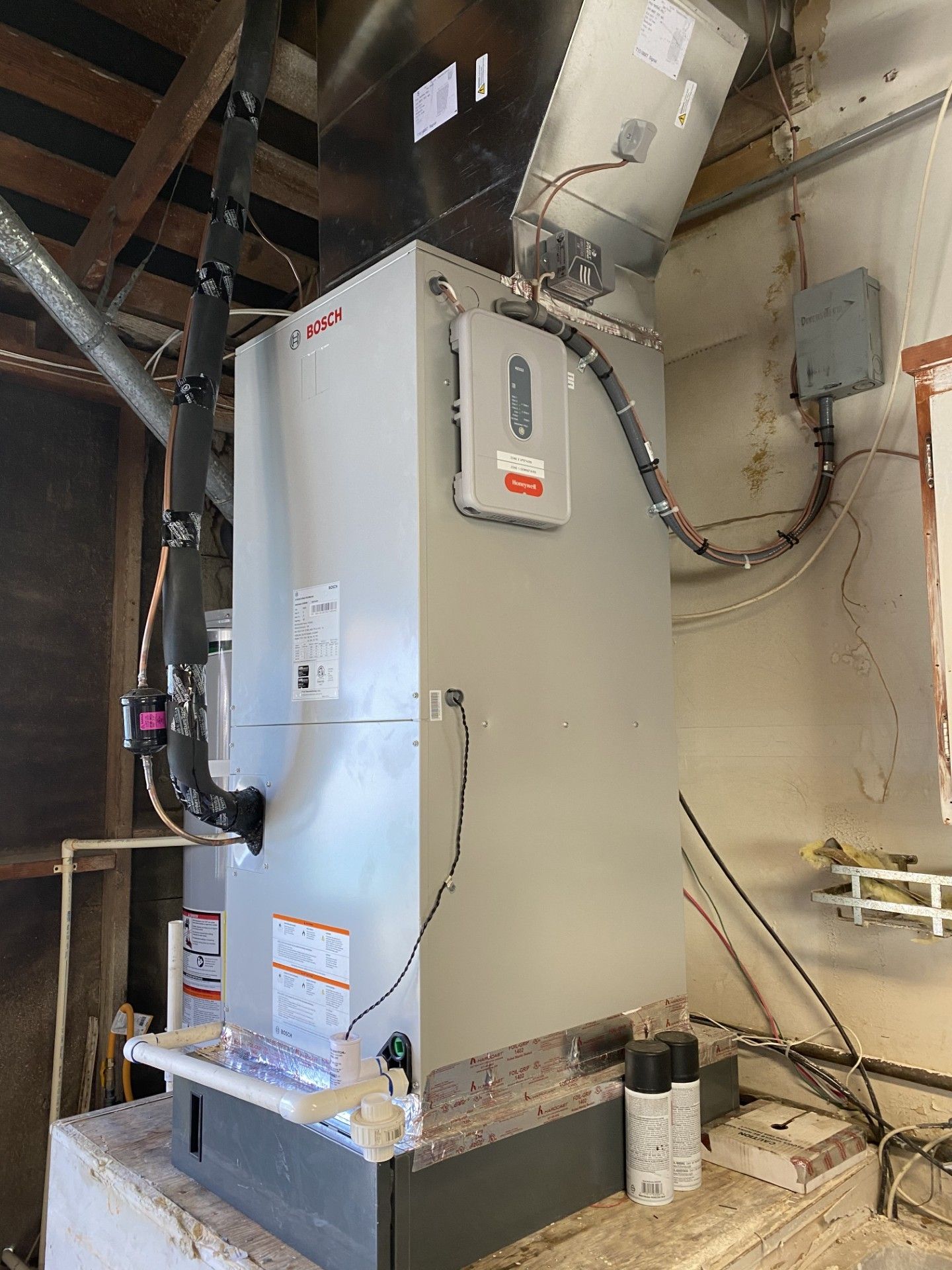 A Lennox HVAC system in a basement with ducts and wiring.