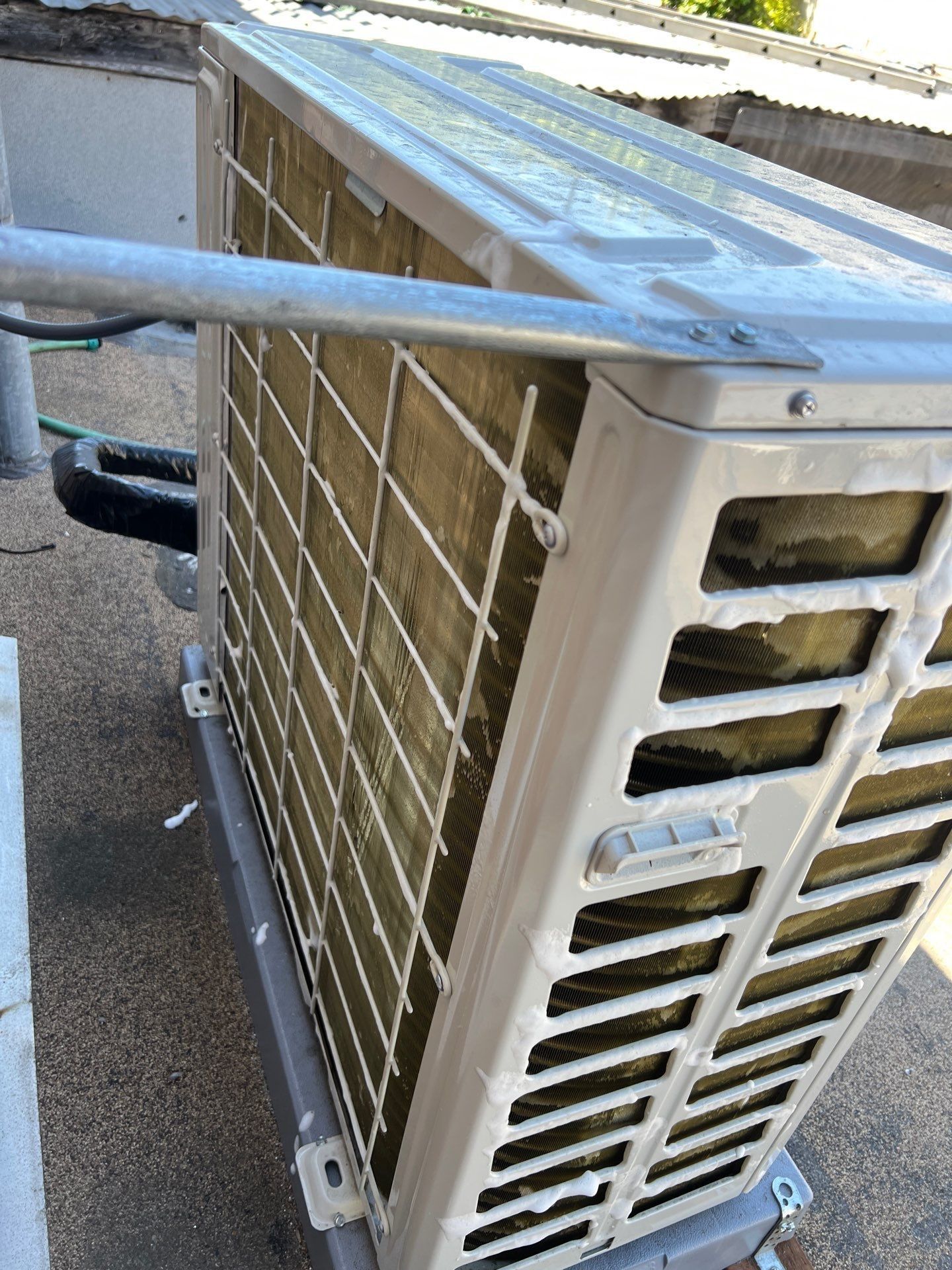 Outdoor air conditioning unit with metal frame, visible coils, and rectangular vents.