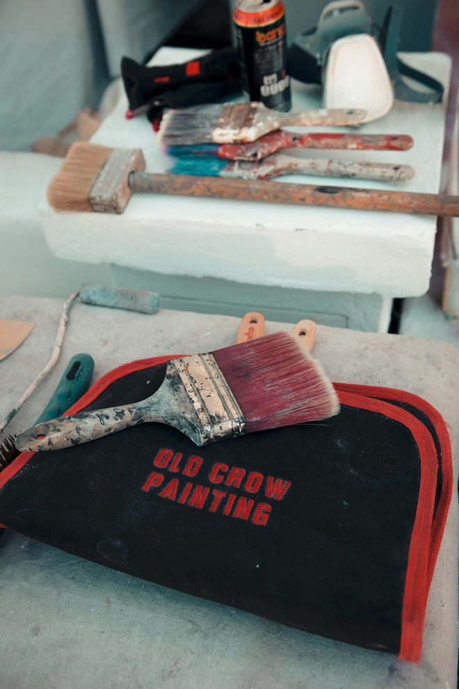 Toolbox with a black-and-red sanding glove, hand tools, and a spray can on foam packaging