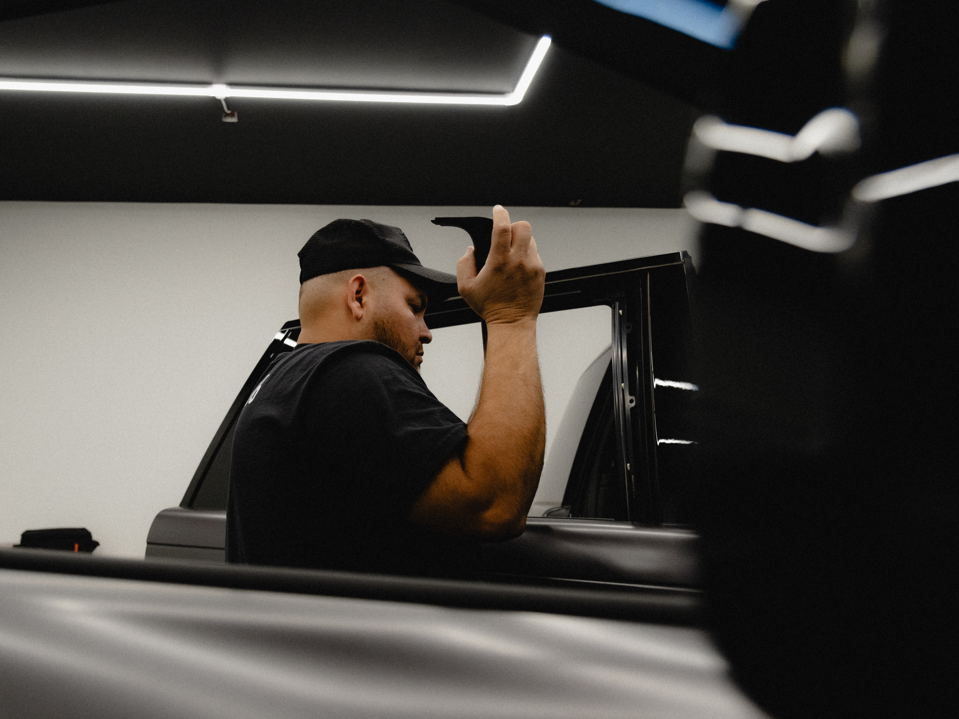 A man is applying window tinting to a car window.