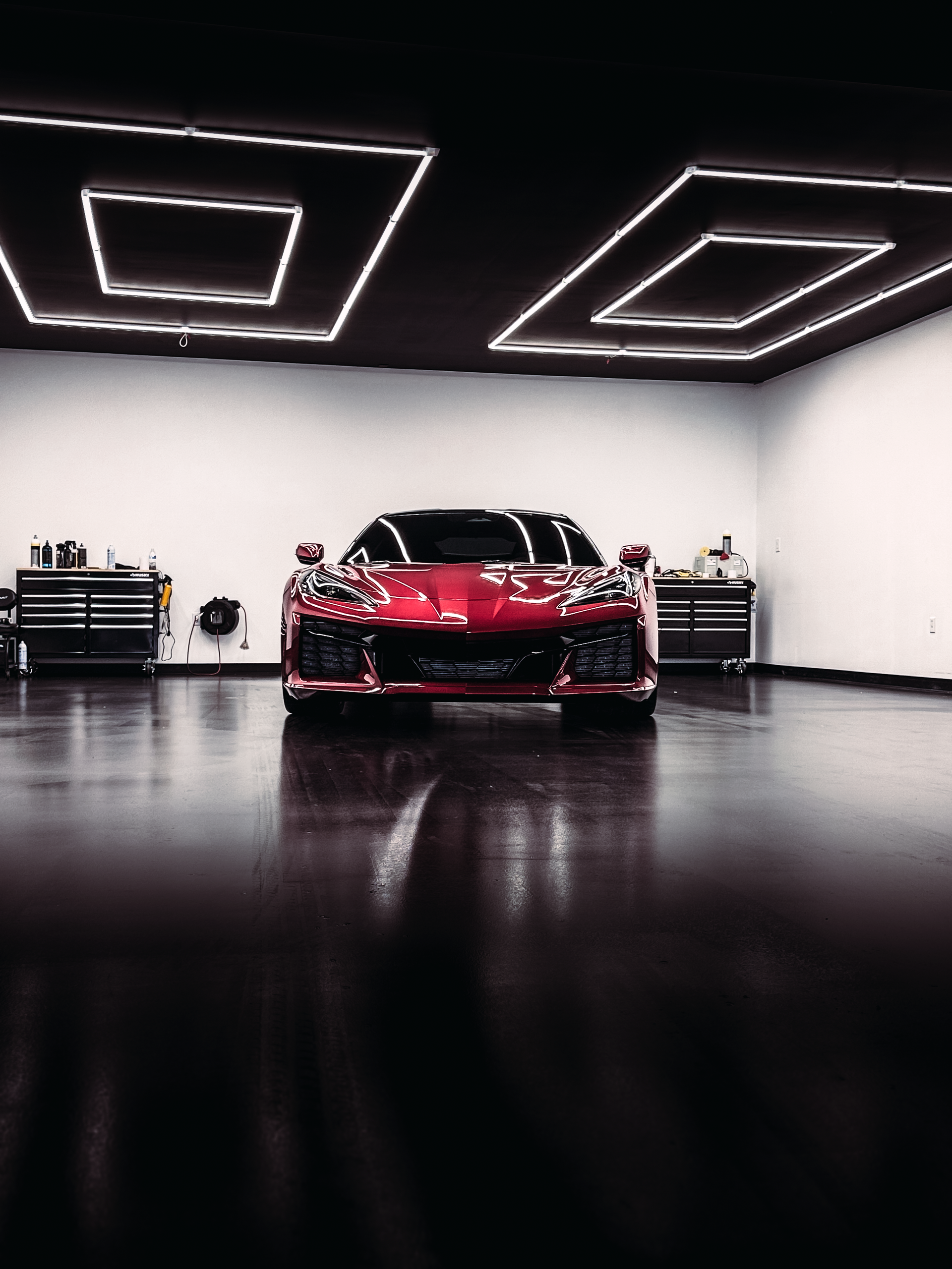A red sports car is parked in a garage.