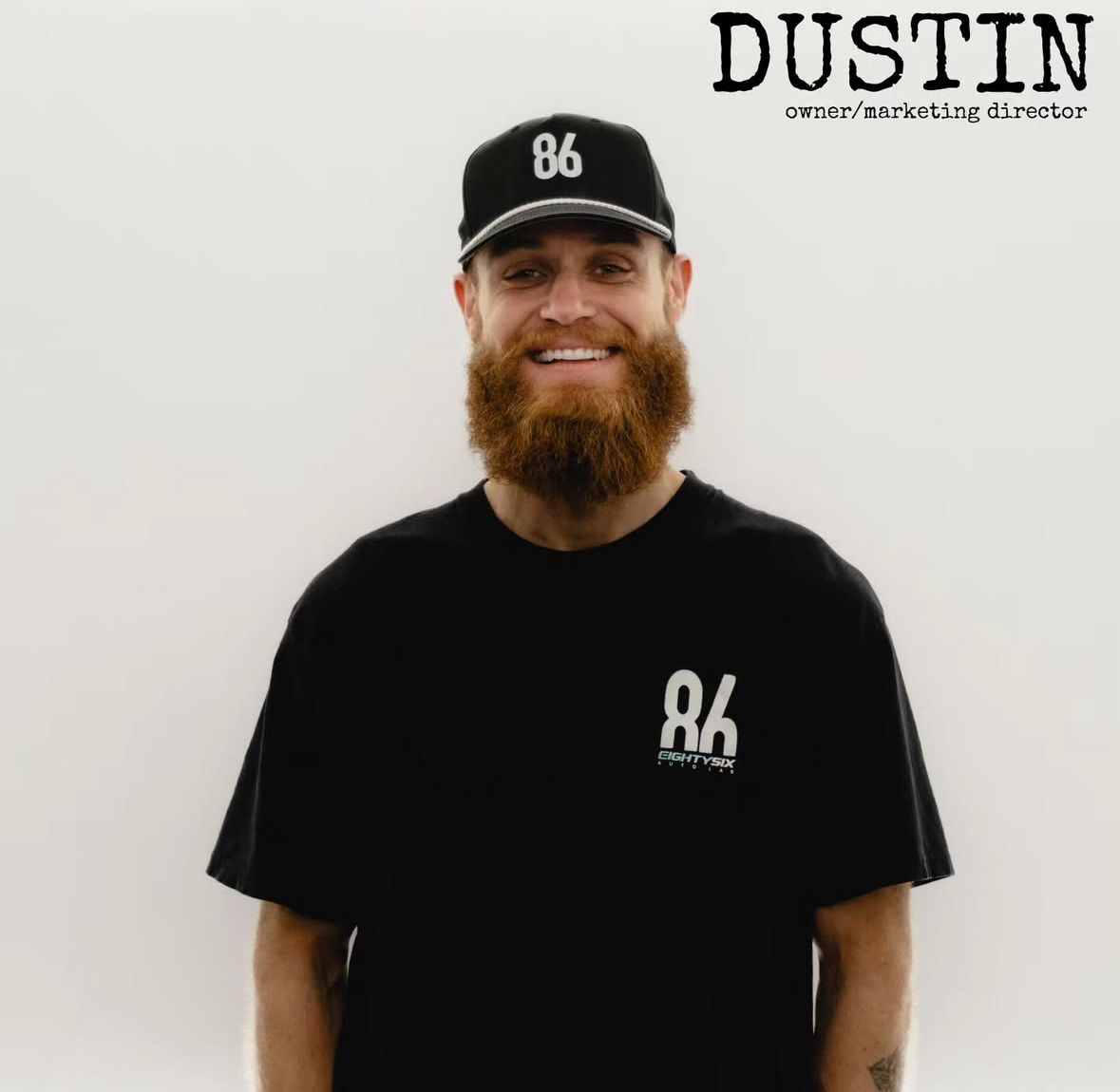 Smiling bearded man in black B6 hat and shirt against a white background, with “DUSTIN” text above