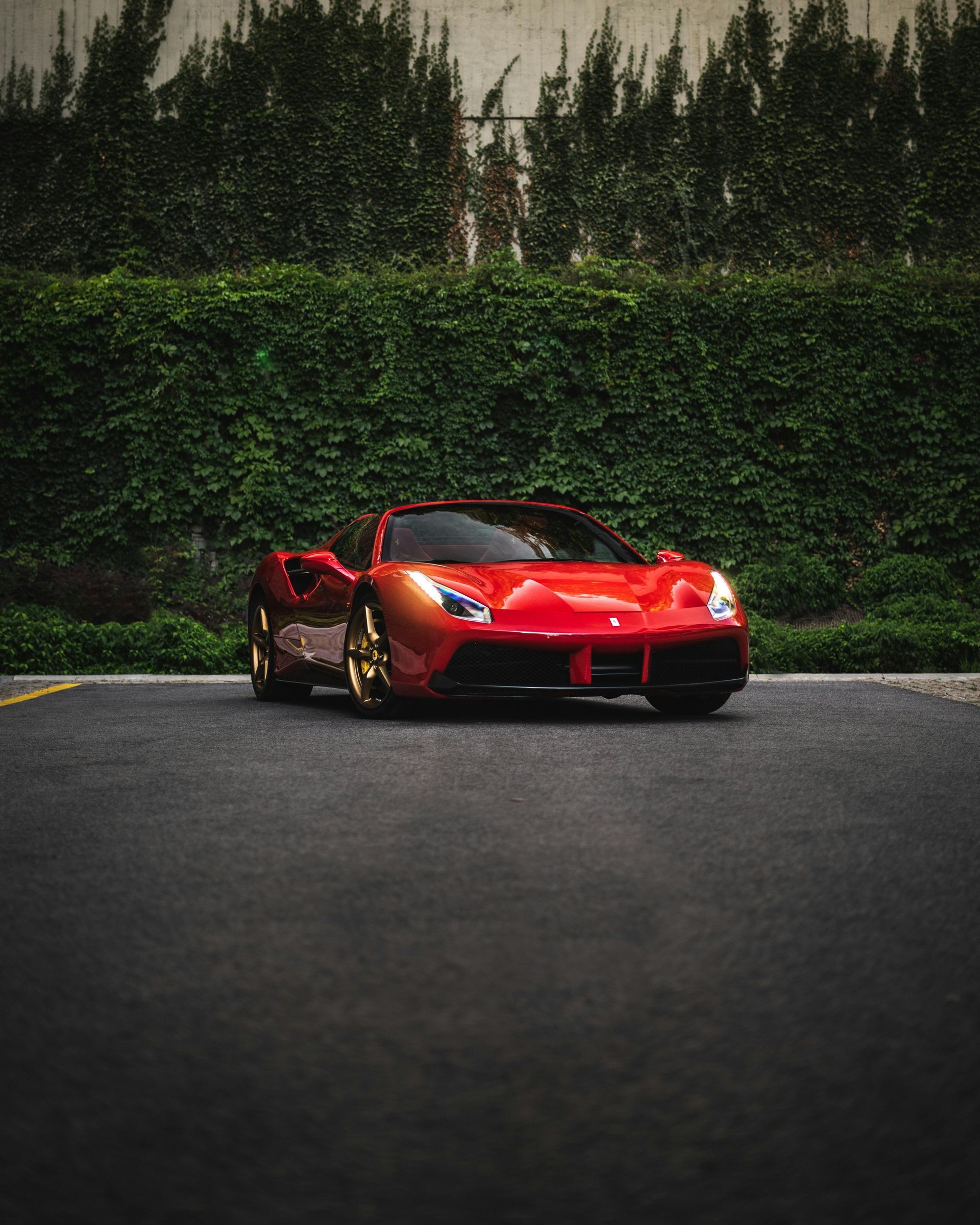 A red sports car is parked on the side of a road.