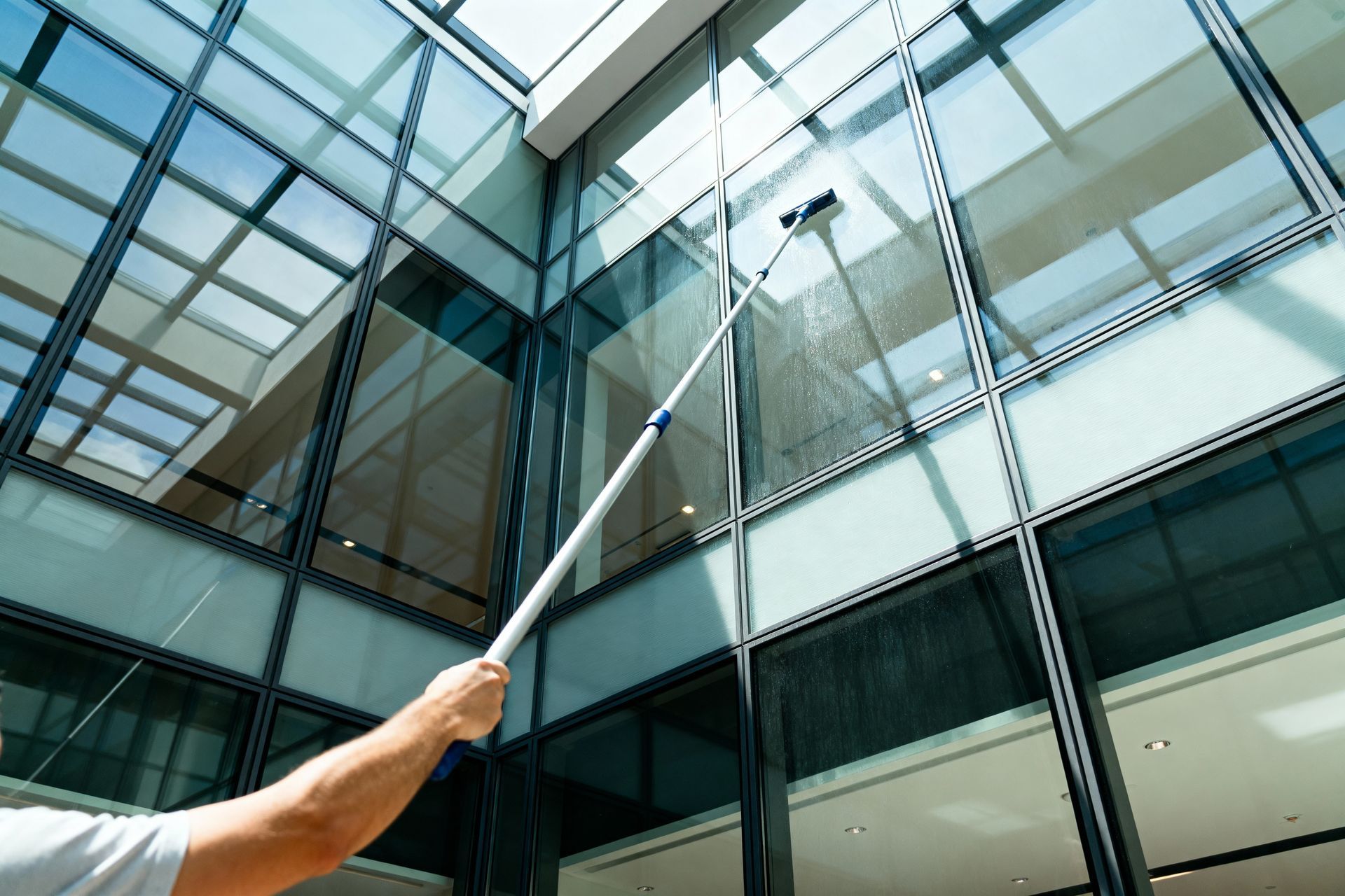 Person pointing at a modern glass office building facade