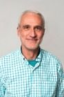 A man in a plaid shirt is smiling for the camera.