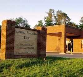A brick building with a sign in front of it that says internal medicine east.