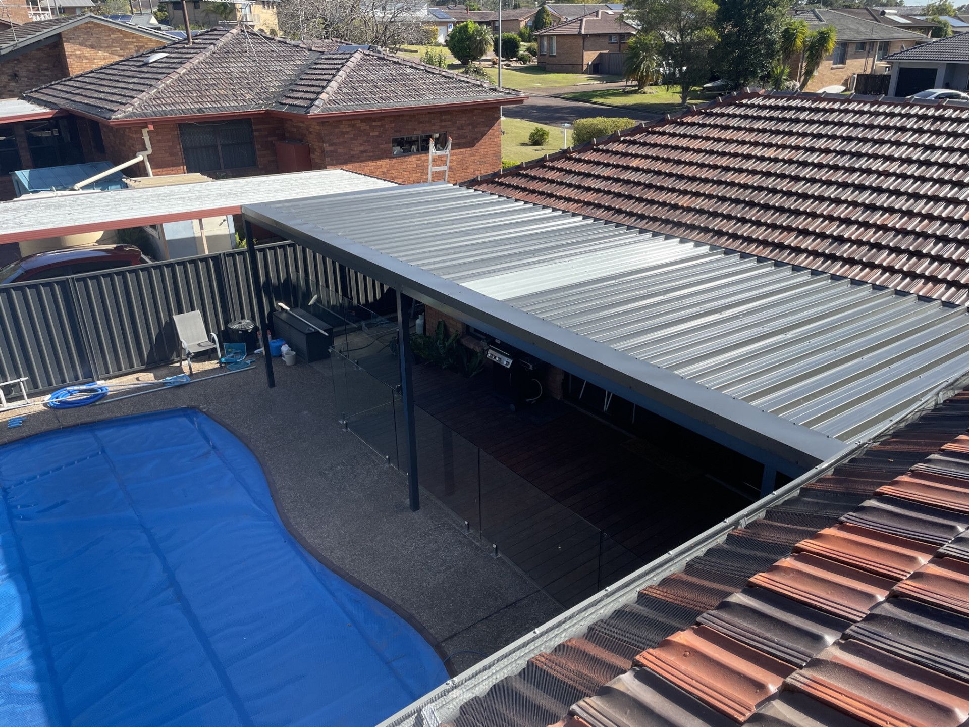 A Backyard With A Pool And A Awning Cover - Kimick Roofing Solutions In Wyong, NSW
