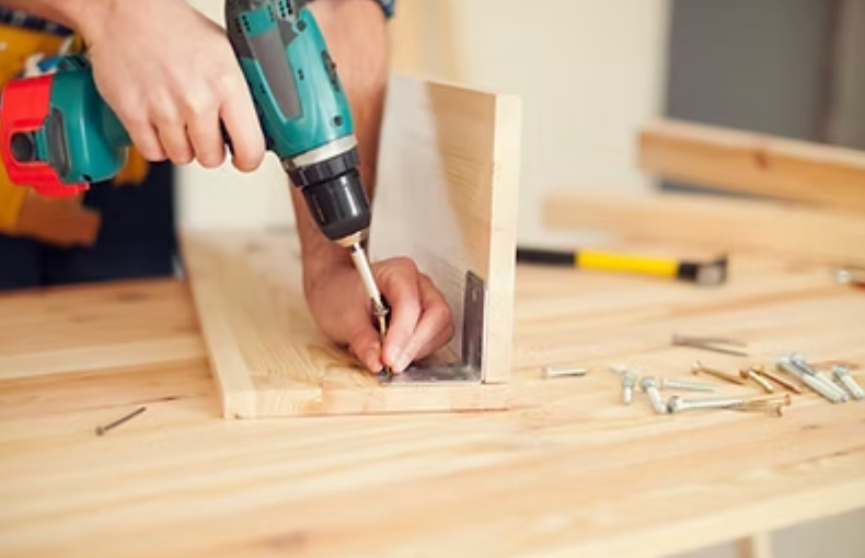 Hands working with tools on wood; detail of woodworking.