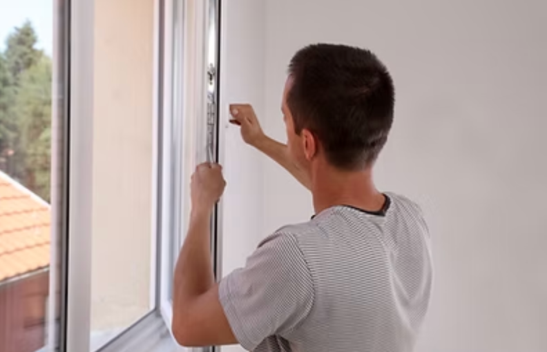 People shaking hands over blueprints at a desk with construction tools.