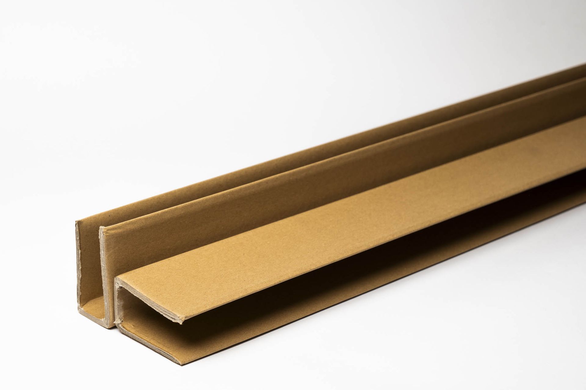 Profilo a U in metallo marrone con interno dorato, mostrato su sfondo bianco.