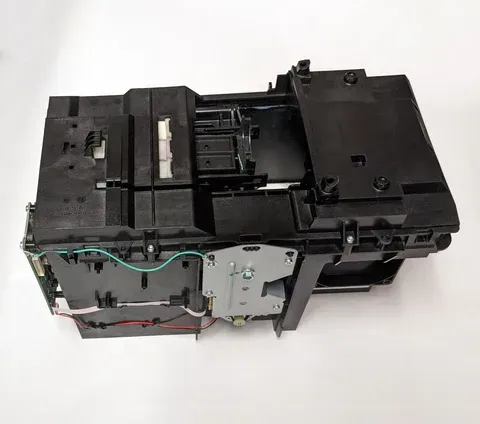 Black plastic printer/scanner mechanism with exposed wires and metal components on a white background