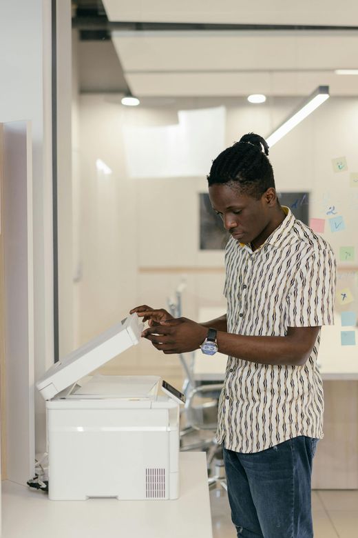 Person using a copier in a bright office hallway