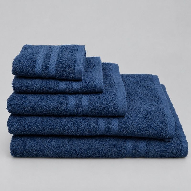 Stack of clean, white towels, one rolled on top.